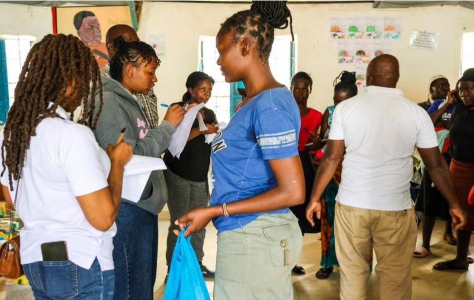 AEK Staff signing up the flood victims as they receive their food bas.png