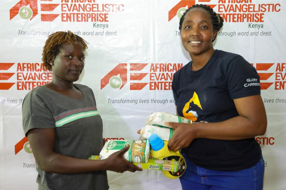 Ann Wanjiru, Finance Manager, AE Kenya giving food packs at one of the distribution centers.